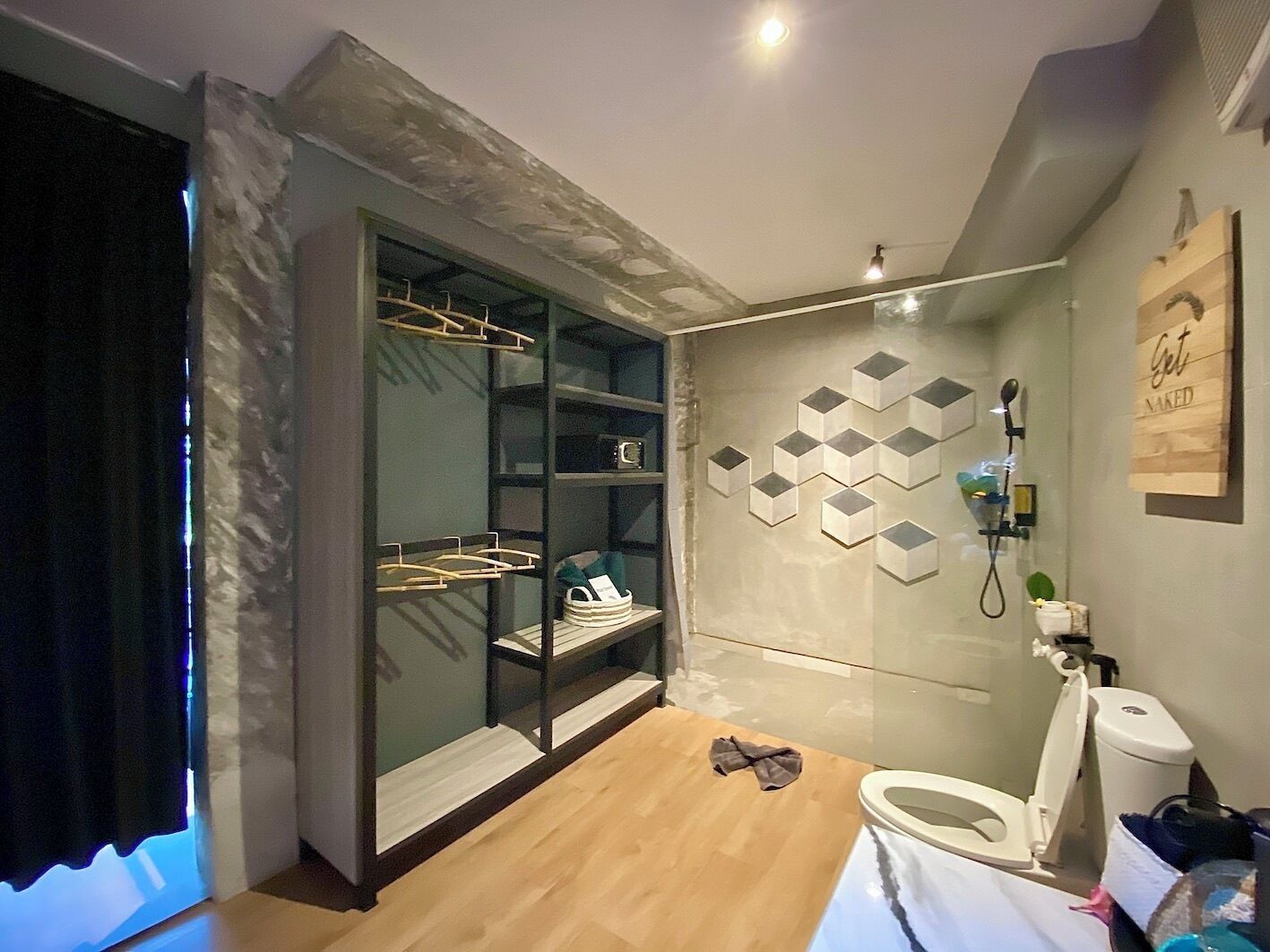 Une salle de bain moderne avec un dressing, une douche équipée d’un pommeau de douche amovible et des toilettes.