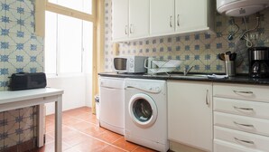 A compact kitchen with a washing machine, microwave, and a coffee maker. - Central Downtown Rossio by Central Hill (Lisboa ciudad)