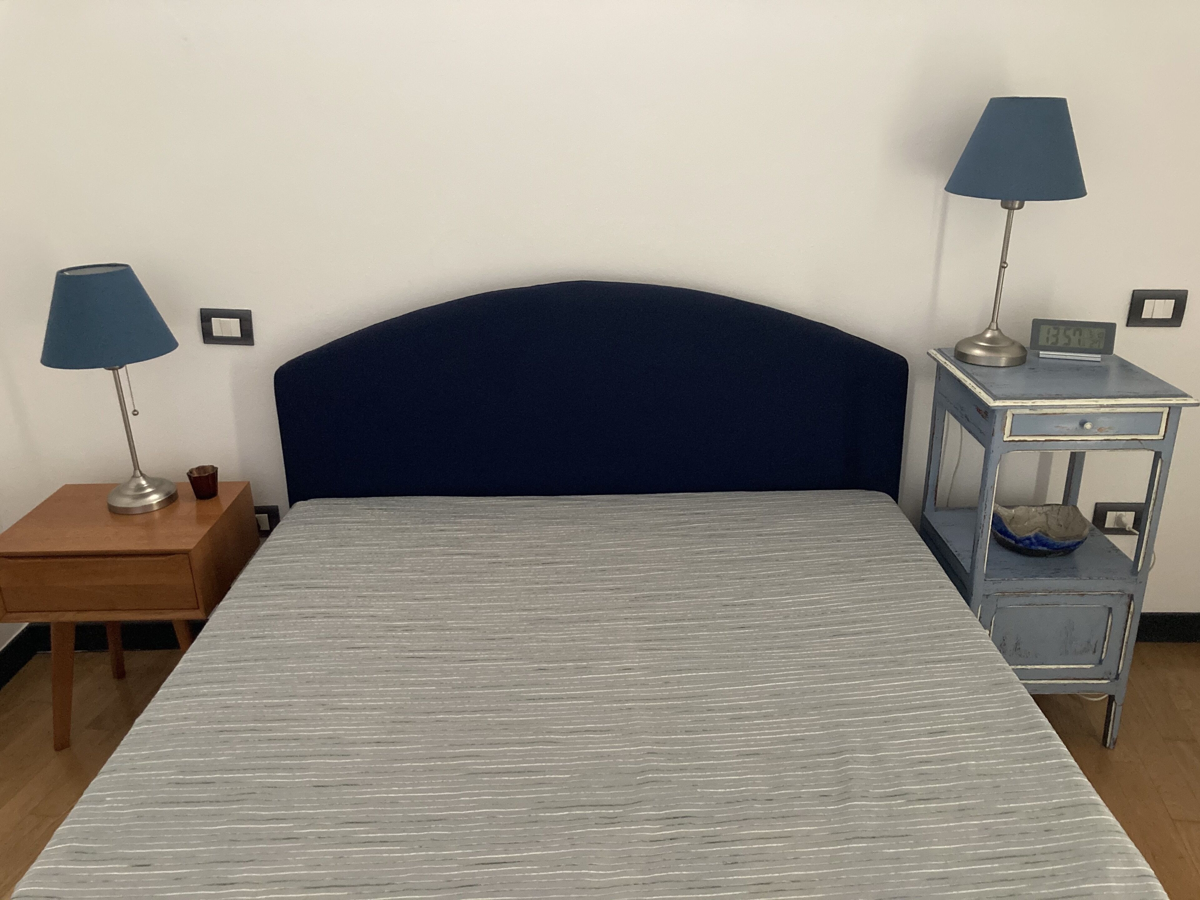Un dormitorio con una cama, dos mesitas de noche y dos lámparas.