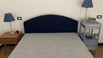 Un dormitorio con una cama, dos mesitas de noche y dos lámparas.