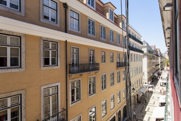 A multi-story building with balconies and a pedestrian street.
