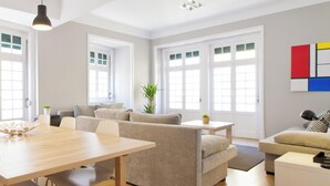 A modern living room with a wooden dining table, two sofas, and a coffee table.