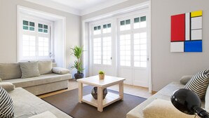 A modern living room with a sofa, a coffee table, and a potted plant.
