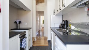 Una cocina moderna con horno empotrado, cafetera y lavaplatos.