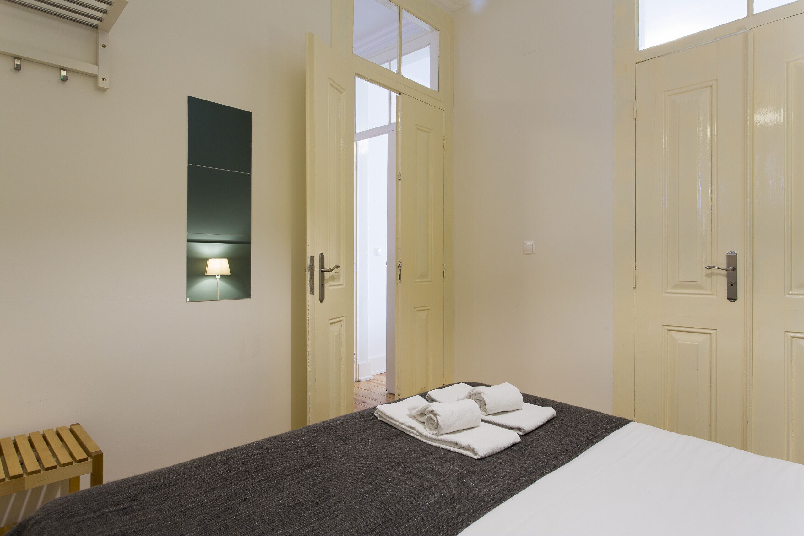 Ein Hotelzimmer mit einem Bett, einem kleinen Tisch und einer Wandleuchte.