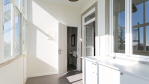 A bright, well-lit hallway with a modern kitchen area, large windows, and a view of the outside.