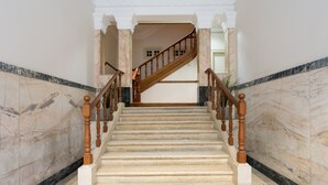 A marble staircase with wooden balusters leading to a landing.