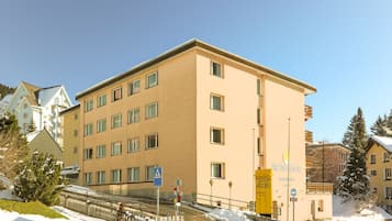 A multi-story hotel with a beige facade, multiple windows, and a visible entrance.