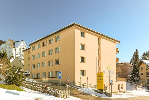 Un hôtel à plusieurs étages, doté d’une façade beige, de nombreuses fenêtres et d’une entrée bien visible.