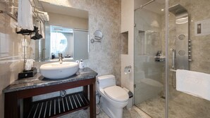 Een moderne badkamer met een groot wastafel, toilet en een douchecabine met glazen wanden.