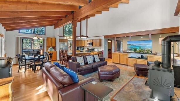 A spacious living area with a fireplace, leather furniture, and a kitchen in the background. - Hot Tub! Gas Fireplace! Two Decks, Garage, New Flooring, Pets OK! (Kings Beach)