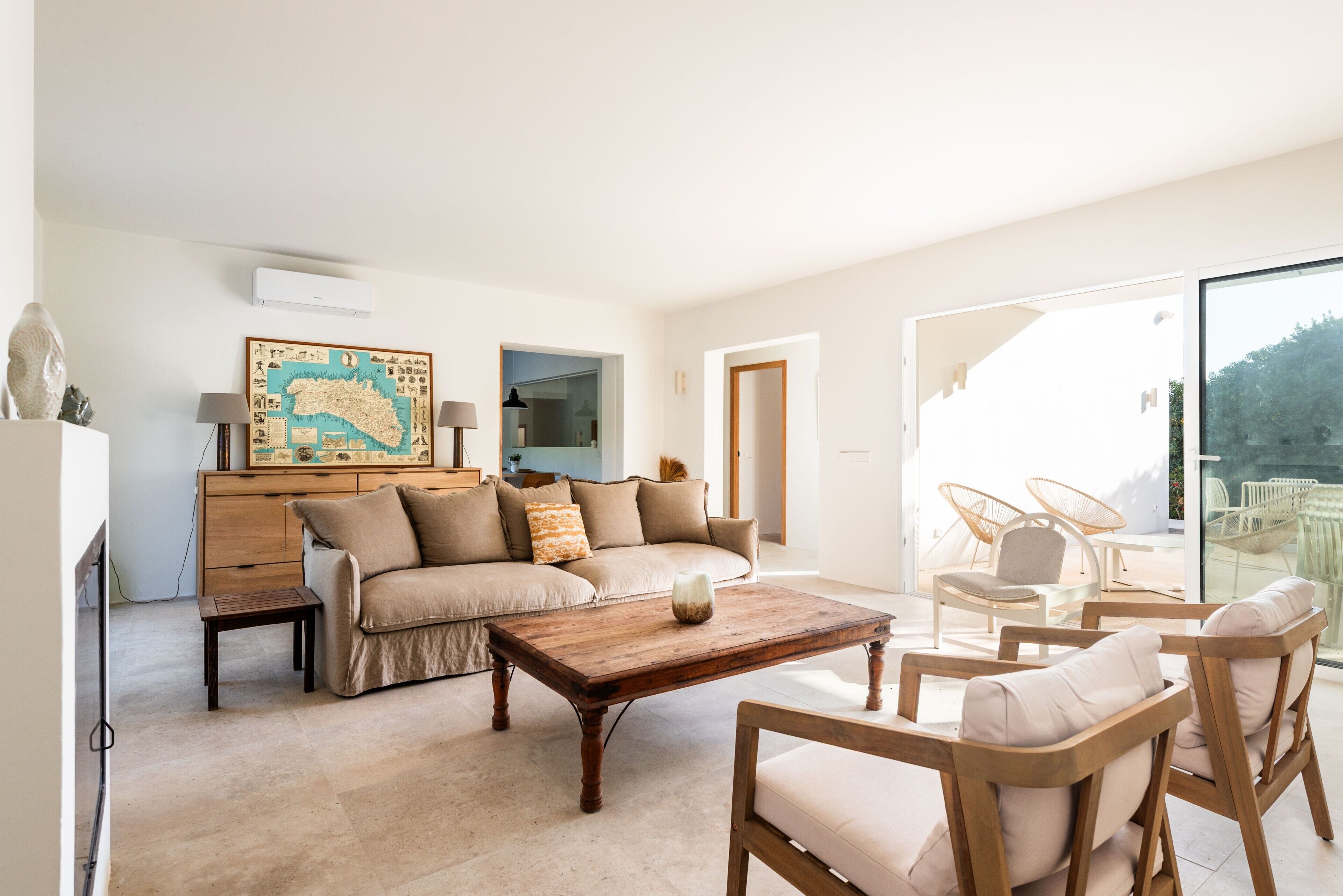 A living room with a sofa, coffee table, and wicker chairs.