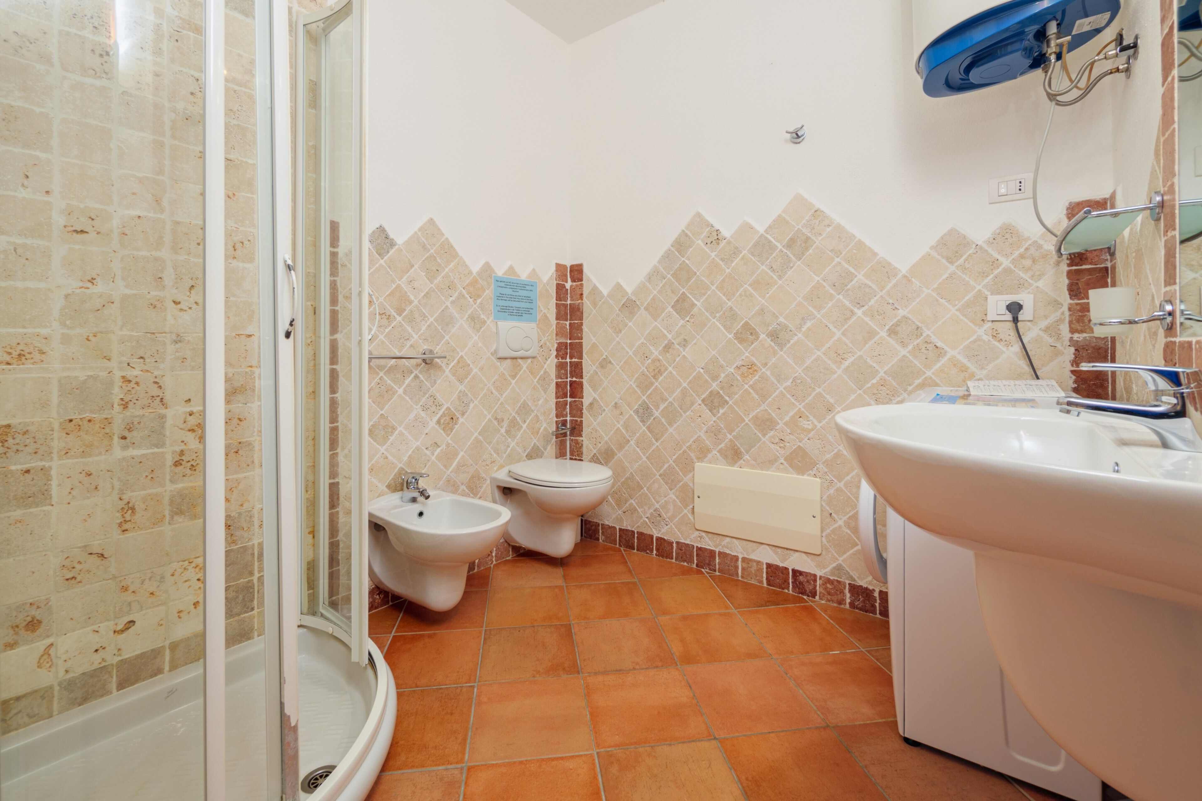 Un baño con ducha, bidé, inodoro y lavamanos.