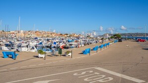 A marina with numerous boats docked, a clear sky, and a distant town. - Apartment "Casa Erica" with Sea View, Wi-Fi & Private Terrace (Palau)