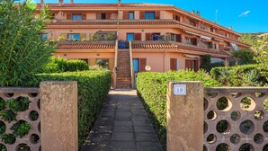 A multi-story building with a central entrance, a staircase, and a gate with numbered signs. - Apartment "Casa Erica" with Sea View, Wi-Fi & Private Terrace (Palau)