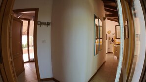 A hallway with a sign reading "Chalet" on the wall, leading to a kitchen area with a stove and cabinets. - Alghero magnificent villa Laurus with pool in Valverde 122 D (Alghero)
