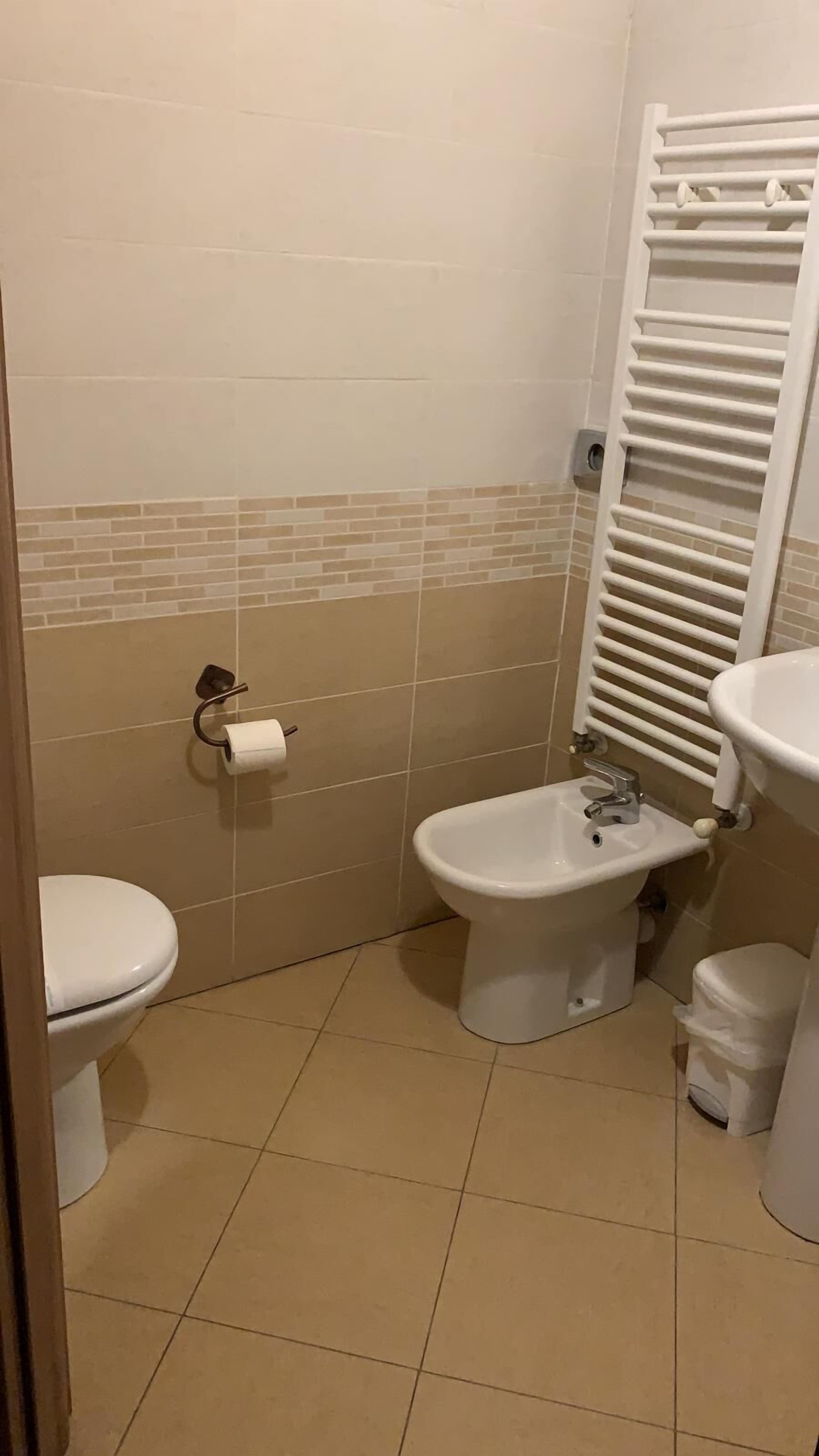Ein kleines Badezimmer mit Toilette, Bidet und Waschbecken.
