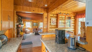 A log cabin interior with a kitchen, dining area, and living room. - Big Bear Retreat - 2 Fireplaces, Deck, Barbecue, Fenced Yard (Big Bear Lake)