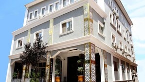 A multi-story hotel with a classic architectural design, featuring a prominent entrance with decorative columns and potted plants. - Ridvan Otel (Bursa)