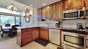 A modern kitchen with wooden cabinets, stainless steel appliances, and a large island. - Deluxe Condo with Fireplace (Unit 623 at 1849) (Mammoth Lakes)
