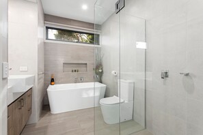 Ein modernes Badezimmer mit freistehender Badewanne, Toilette und einer Duschkabine.