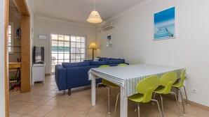 A compact living space with a dining area, a sofa, and a TV.