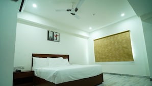 A bedroom with a bed, nightstand, and a ceiling fan.