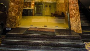 The exterior of the Welkin Hotel with a modern facade, large glass entrance, and marble columns.