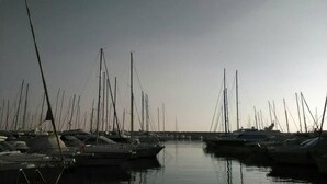 Puerto deportivo con varias embarcaciones amarradas en aguas tranquilas.