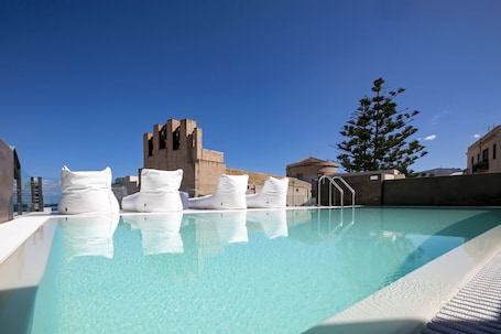 Una piscina al aire libre, sillones reclinables de piscina