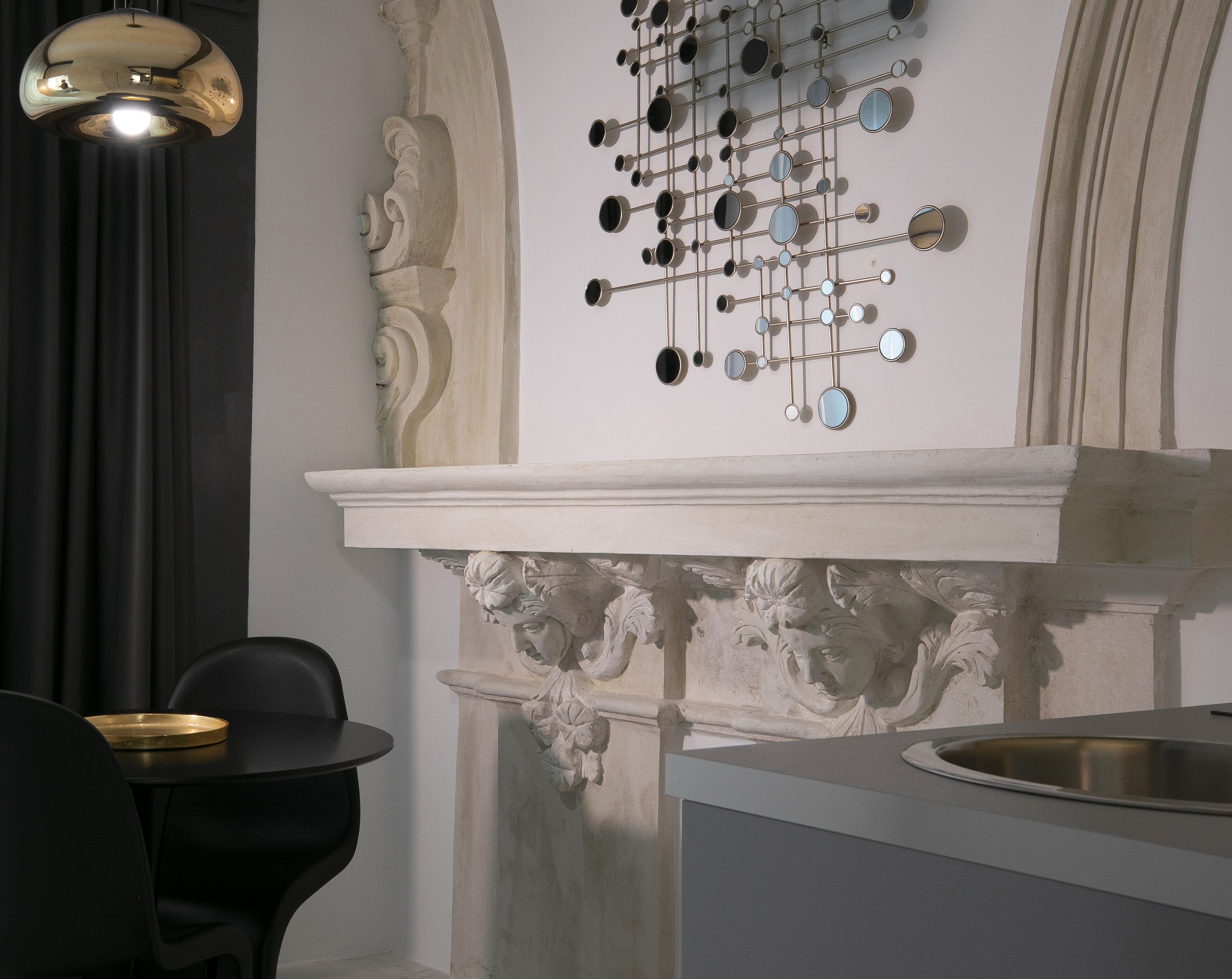 A modern interior with a decorative wall, a chandelier, and a minimalist dining area.