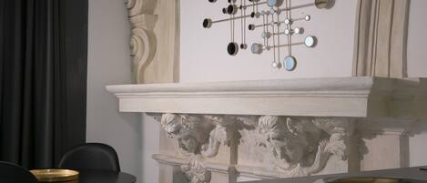 A modern interior with a decorative wall, a chandelier, and a minimalist dining area.
