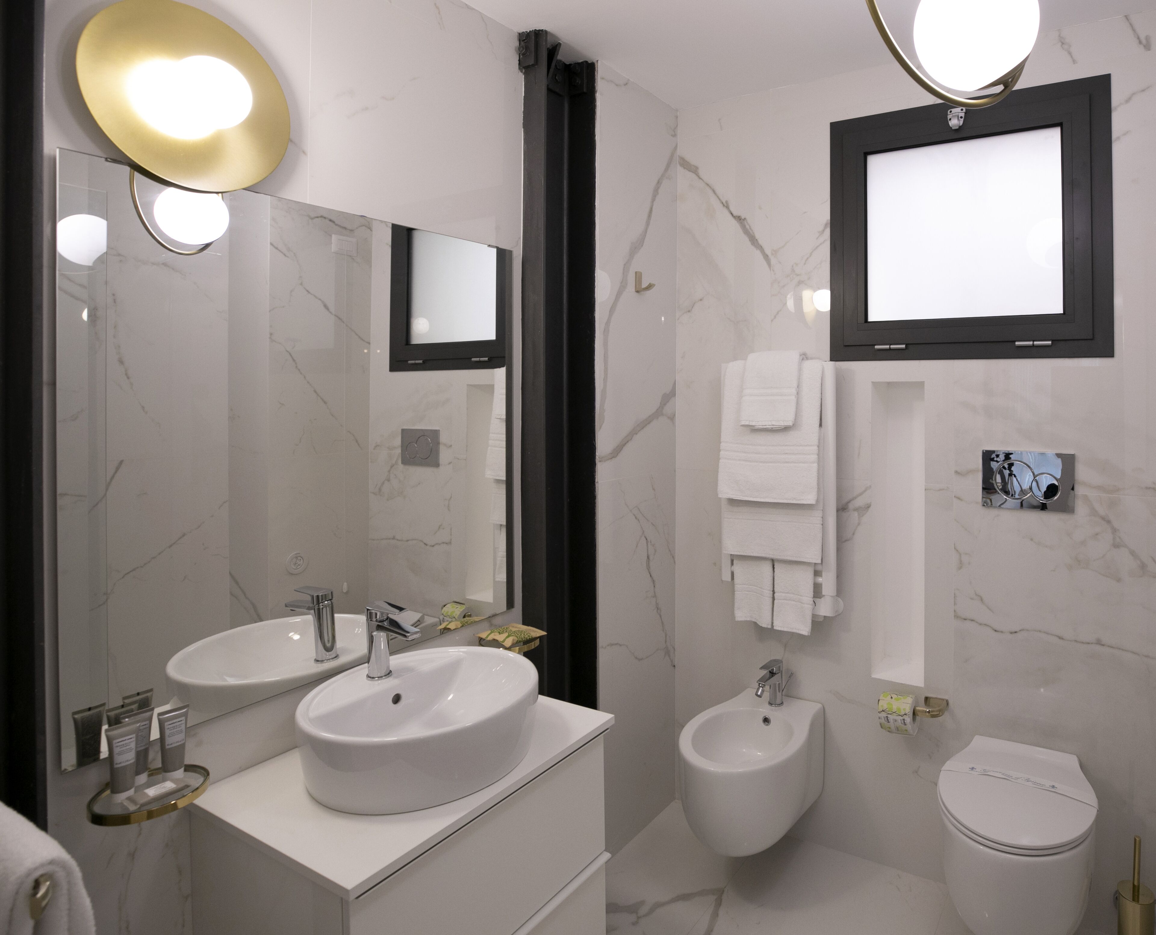 A modern bathroom with two sinks, a bidet, and a toilet.