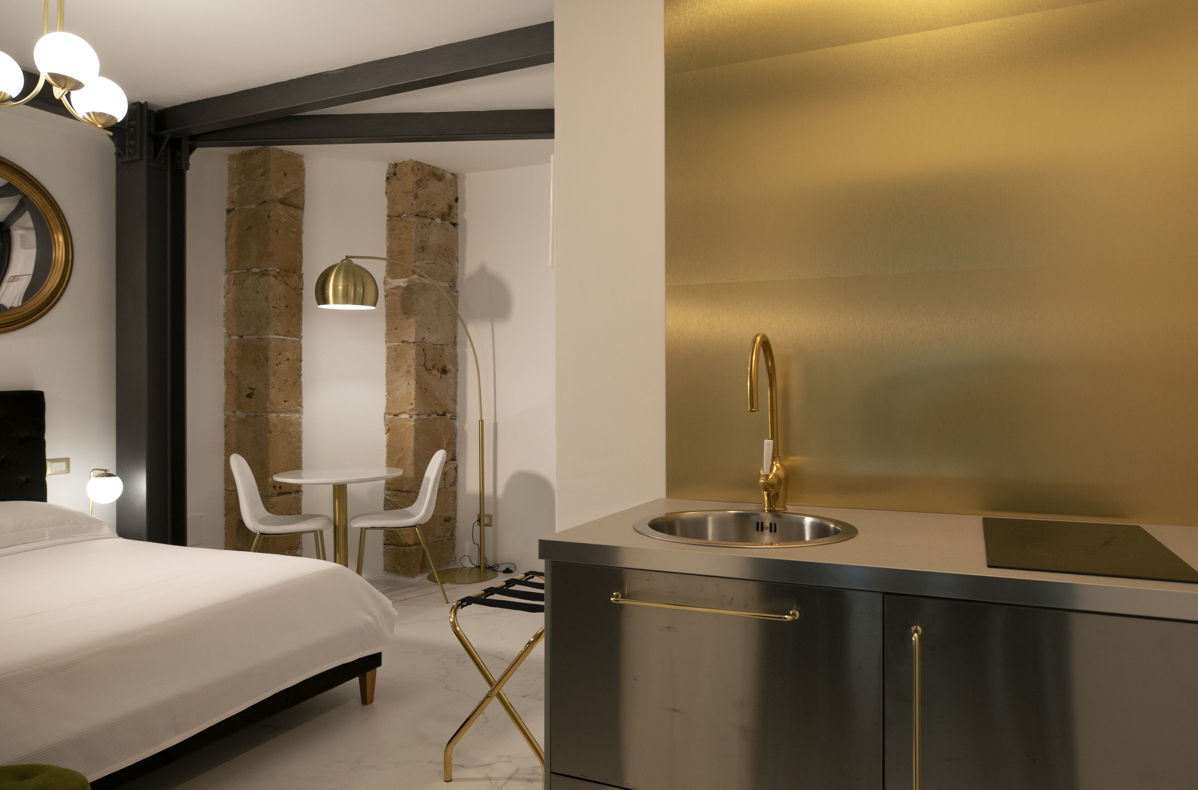 Habitació d'hotel moderna amb un llit, una taula rodona petita, una cadira, un escriptori i un envàs de bany integrat.