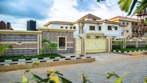 A gated residential complex with multiple houses, a paved driveway, and a small lawn area. - Ubiq Suites and Apartments (Abuja)