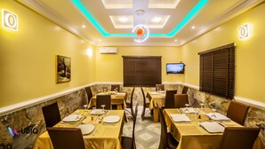 A conference room with tables set for a meeting, equipped with chairs, plates, and cutlery. - Ubiq Suites and Apartments (Abuja)