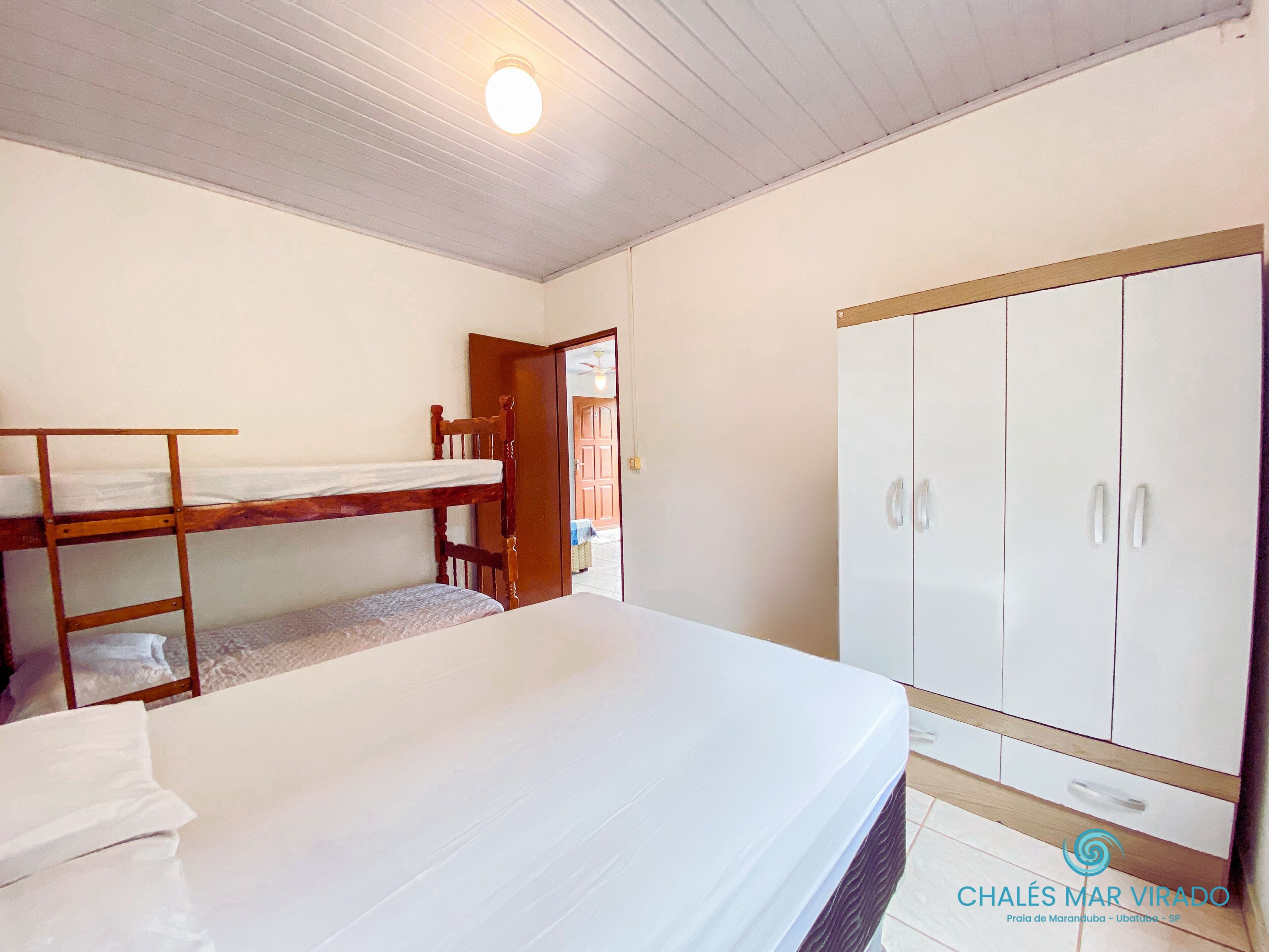 Una habitación con literas, un armario y una lámpara en el techo.