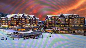 Een hotel met meerdere verdiepingen, met een skilift op de voorgrond.