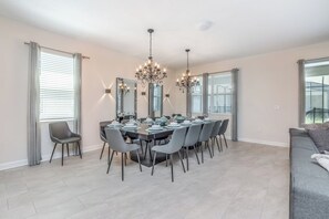 Un comedor con una mesa larga, varias sillas y candelabros.