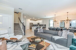 A modern living room with a sofa, coffee table, and a staircase leading to an upper level.