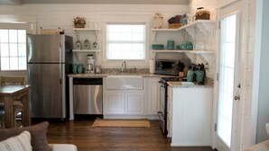 A kitchen with white cabinets, stainless steel appliances, and teal accents. - Mtn Cabin Lake Hot Tub | Kayak | Fish | AtvTrls (MENA)