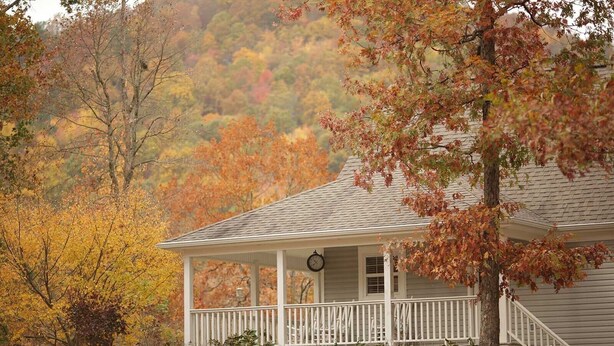 A white house with a porch and a clock. - Mtn Cabin Lake Hot Tub | Kayak | Fish | AtvTrls (MENA)