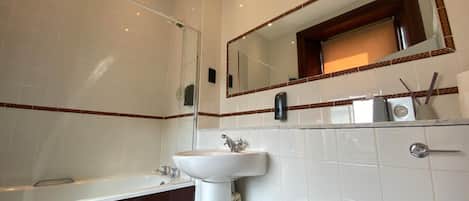 A modern bathroom with a bathtub, a sink, and a toilet.