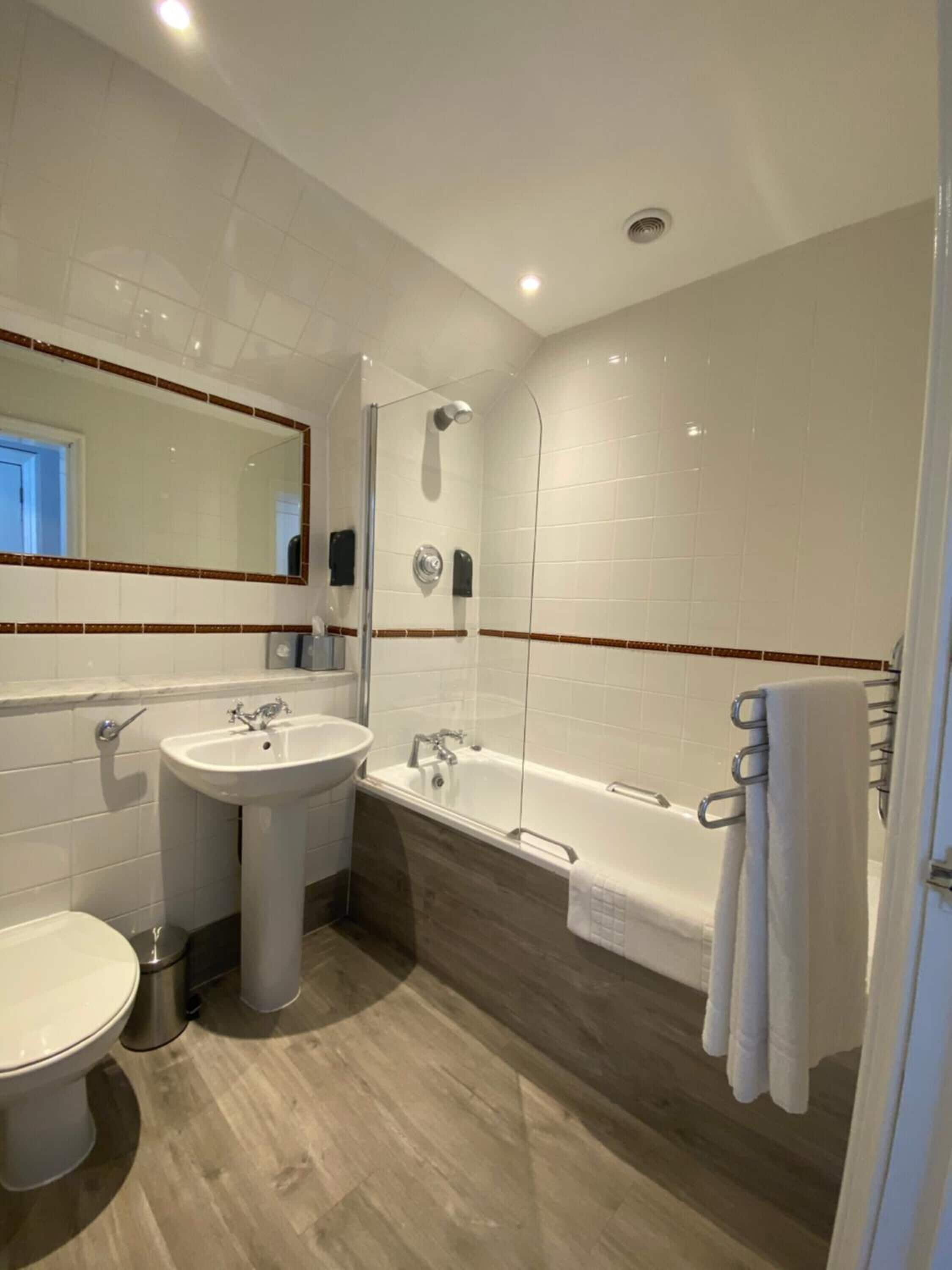 Ein modernes Badezimmer mit Toilette, Waschbecken und Badewanne.
