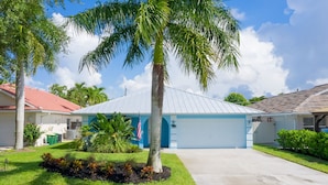 A residential property with a garage, a well-maintained lawn, and a palm tree. - 3 Bedroom, Huge Pool, Hot Tub, Screened in Lanai in the coveted 500 block (Naples)