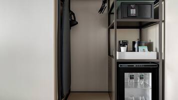 A compact kitchenette with a coffee machine, a refrigerator, and a microwave.