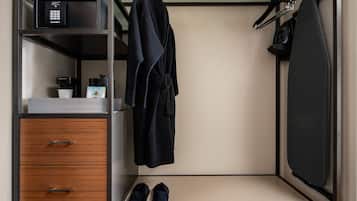 A compact room with a wardrobe, a coffee maker, and a pair of shoes.
