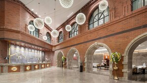 Un hall d’entrée spacieux, doté d’un haut plafond, de grandes fenêtres et d’un comptoir d’accueil.