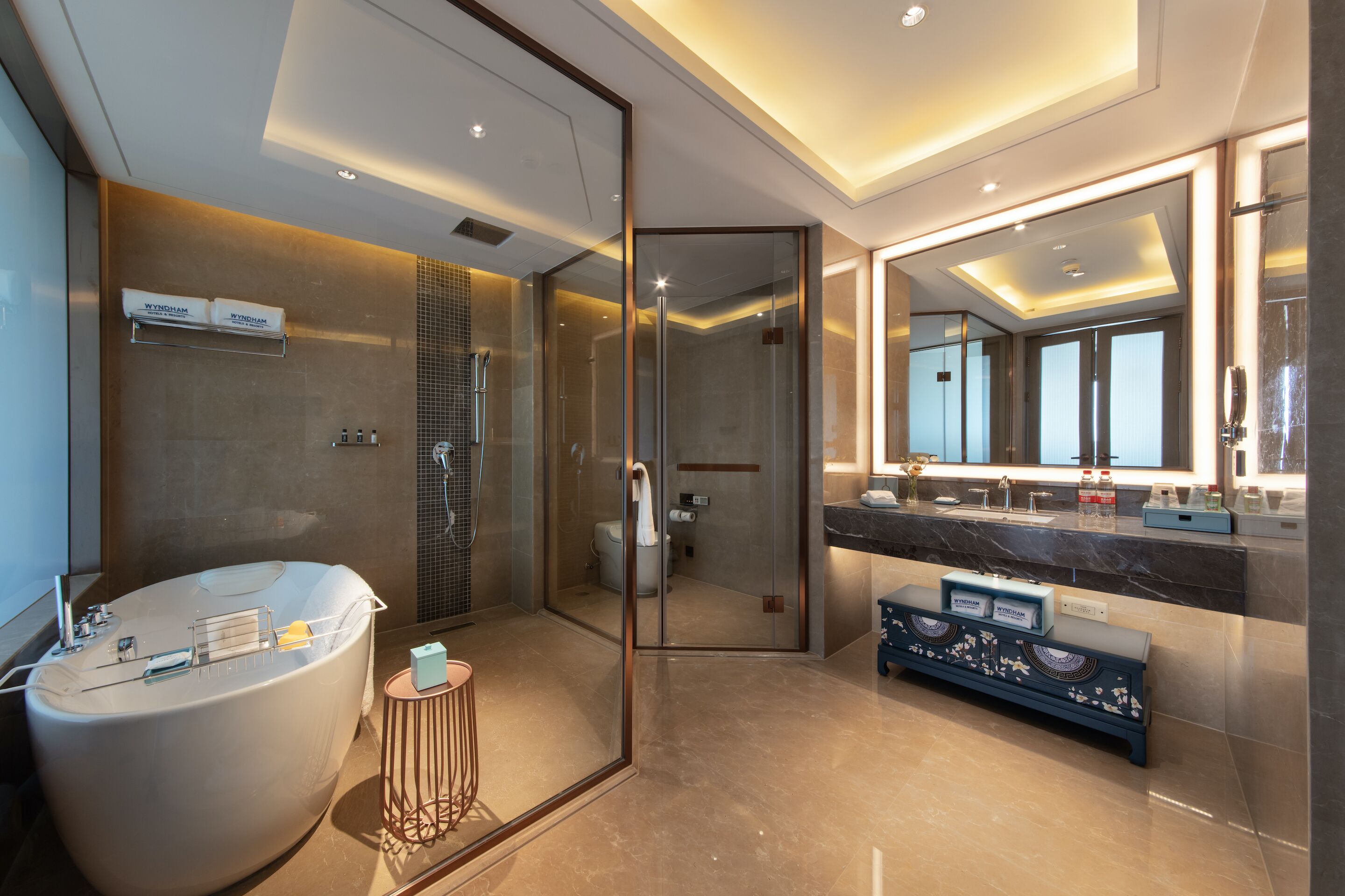A modern bathroom with a freestanding bathtub, a glass-enclosed shower, and a vanity with a large mirror.