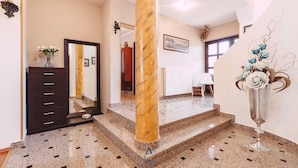 A spacious hallway with a marble column, a dark wooden dresser, and a decorative vase with flowers. - Gorgeous 5-BR Villa with private heatable pool near Pula (Fažana)